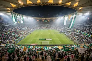 Packed floodlit stadium in Jeddah with Saudi and UAE fans waving flags ahead of the Arabian Gulf Cup 27 final