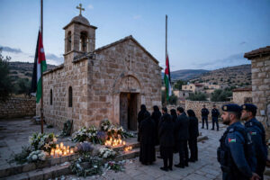 Mourners gather outside St George's Greek Orthodox Church in Hamoud, Karak, Jordan, as funerals are held for the victims of the church attack
