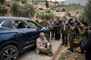 A tense confrontation on a rural road near the Palestinian Christian village of Taybeh in the occupied West Bank during olive harvest season, with diplomatic vehicles and bystanders