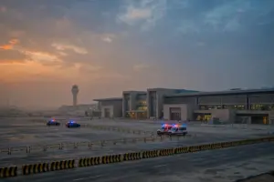 Emergency vehicles parked outside King Khalid International Airport terminal in Riyadh at dusk after operations were suspended