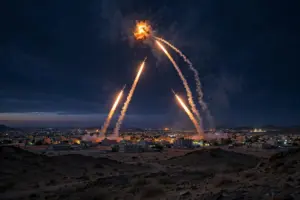 Saudi air defence interceptor missiles streak into the night sky over a desert city as coalition forces down incoming drones