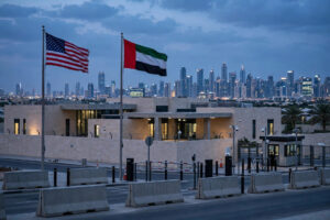United States embassy compound at dusk with the American and UAE flags flying, Dubai skyline behind